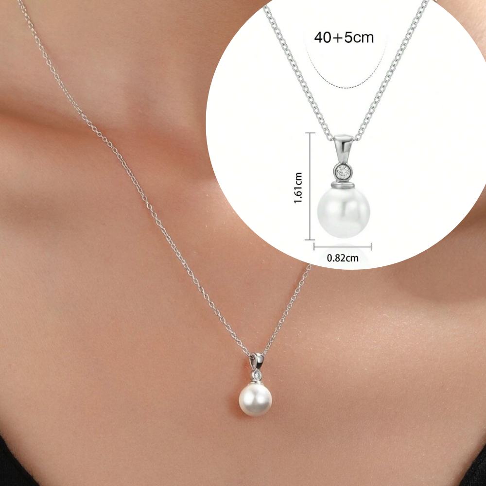Personalizirana srebrna verižica z vgraviranim imenom in datumom, obdana z majhnimi kristali, kot idealno darilo za Dan žena. Elegantna darilna škatla na beli podlagi z rdečo vrtnico ob strani, simbolizira ljubezen in spoštovanje na poseben dan