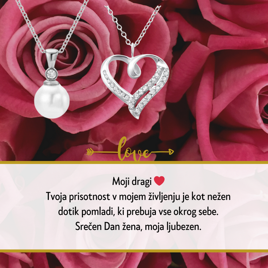 Personalizirana srebrna verižica z vgraviranim imenom in datumom, obdana z majhnimi kristali, kot idealno darilo za Dan žena. Elegantna darilna škatla na beli podlagi z rdečo vrtnico ob strani, simbolizira ljubezen in spoštovanje na poseben dan